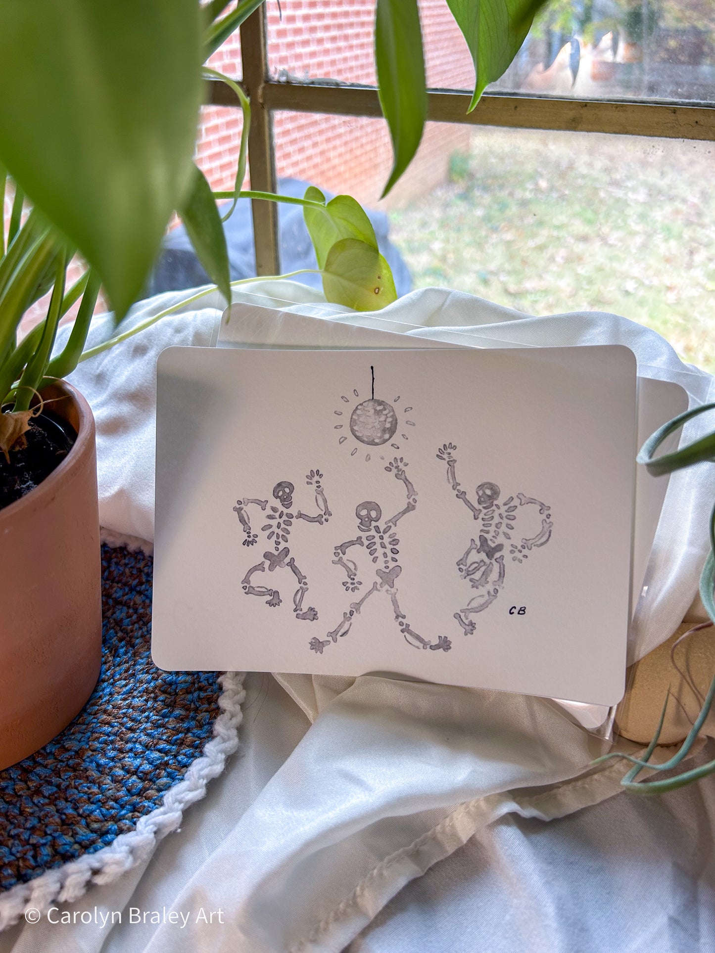 India ink drawn illustration of three dancing skeletons with a disco ball.